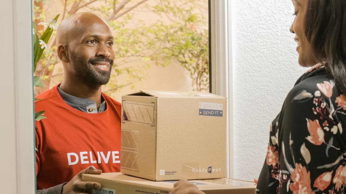 Customer receiving a doorstep delivery from SafaiKart